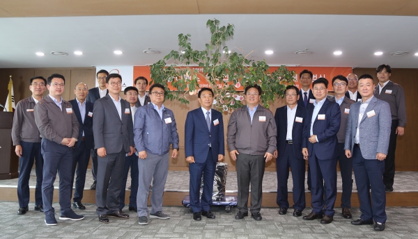 이성수 한화디펜스 대표이사(앞줄 오른쪽 다섯 번째)와 참가자들이 준법을 다짐하는 문구가 적인 메모지를 준법나무에 매단 후 단체사진을 찍고 있다.(사진=한화디펜스)