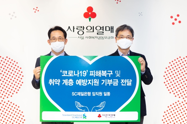 최기훈 SC제일은행 마케팅·커뮤니케이션본부장(사진 왼쪽)이 김용희 서울 사회복지공동모금회 사무처장에게 신종 코로나바이러스 감염증(코로나19) 피해복구 및 지원을 위해 임직원과 은행이 모금한 기부금을 전달하고 있다. (사진=SC제일은행)