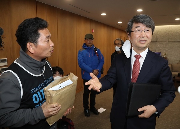 김지형 삼성 준법감시위원장이 3월 27일 서울 서대문구 법무법인 지평에서 열린 시민단체 삼성피해자공동투쟁과의 면담에 앞서 면담에 포함되지 못했다며 억울함을 호소하는 삼성해고자복직투쟁위·삼성중공업피해협력사대책협의회 관계자들과 대화하고 있다. (사진=연합뉴스)