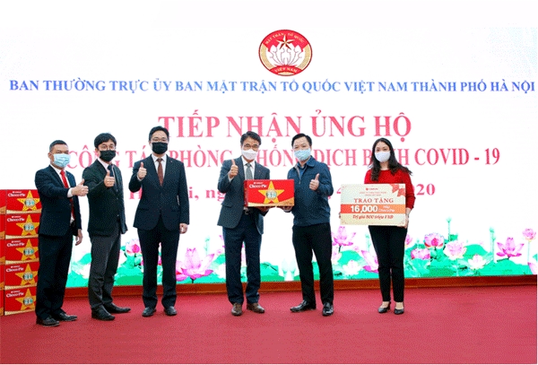 김재신  오리온 베트남 법인 대표이사(오른쪽 셋째)가 응우웬 시 쯔엉 하노이 조국전선위원회 부주석(오른쪽 둘째)한테 코로나 19 극복 응원을 위한 '초코파이'를 건네며 기념사진을 찍고 있다. (사진=오리온)