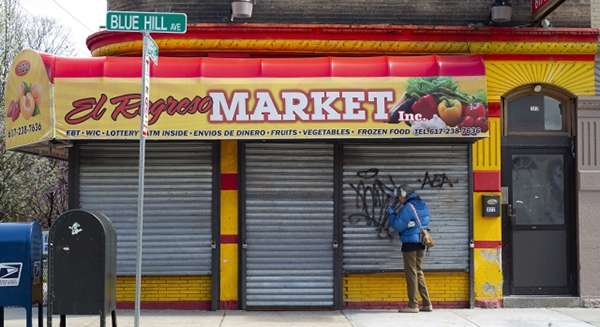 미국에서 코로나19 확산으로 비필수사업장이 영업을 중단한 가운데 14일(현지시간) 매사추세츠주 보스턴에서 굳게 닫힌 상점문 앞에 한 행인이 서 있다. (사진=연합뉴스)