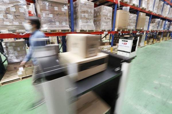 KT 서부물류센터에 적용된 5G 자율주행 운반 카트가 관제실과 작업자의 요청에 따라 스마트폰 등 단말기를 지정된 화물 보관 위치로 자동 운반 하고 있다. (사진=KT)