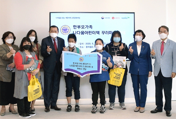 황각규 롯데지주 부회장(왼쪽 넷째), 이정옥 여성가족부 장관(오른쪽 둘째), 이제훈 초록우산어린이재단 회장(오른쪽 첫째)이 25일 서울 송파구 잠실 롯데월드타워에서 한부모 가족에게 '나다움 어린이책'을 건네며 기념사진을 찍고 있다. (사진=롯데지주)