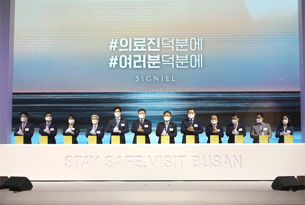 신동빈 롯데그룹 회장(왼쪽 여섯째) 등이 17일 부산 해운대 엘시티 '시그니엘 부산'에서 오른쪽 엄지손가락을 세우고 왼손으로 받치며 코로나19와 싸우는 의료진을 격려하고 있다. (사진=호텔롯데) 