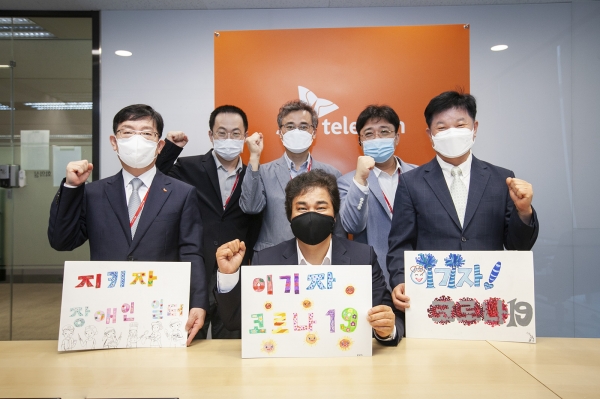 체결식 참석자들이 한국장애인고용공단이 제작한 코로나19 극복 메시지를 들고 결의를 다지는 모습. (사진 아랫줄 가운데)유웅환 SK텔레콤 SV이노베이션센터장. (사진=SK텔레콤)