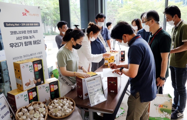 SK이노베이션 직원들이 배터리 공장이 위치한 서산지역 특산품인 육쪽마늘을 판매하고 있다. (사진=SK이노베이션)