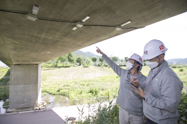KT 직원들이 교량에 설치된 실시간 안전 기가세이프 SOC 장비들을 점검하고 있다. (사진=KT)
