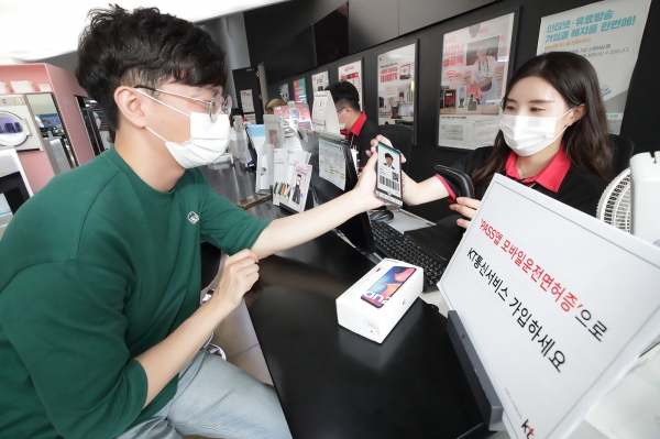 서울 종로구에 위치한 KT스퀘어 방문고객이 새로운 스마트폰으로 기종을 변경하기 위해 패스 앱 모바일운전면허증을 제시하고 있다. (사진=KT)
