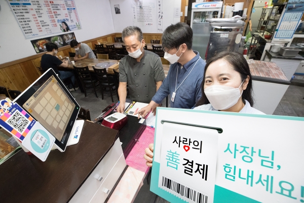 KT 직원들이 광화문 한 주상복합건물의 음식점을 찾아 선결제를 진행하는 모습. (사진=KT)