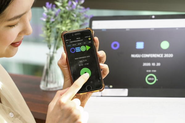 모델이 스마트폰을 사용해 '누구 컨퍼런스 2020' 참가등록을 진행하고 있다. (사진=SK텔레콤)