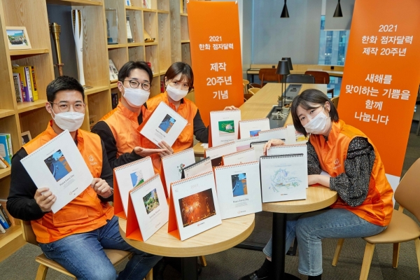 한화 점자달력 제작 20주년을 맞아 한화봉사단 임직원들이 2001년 점자달력부터 시작해 지난 20년간 제작된 한화 점자달력을 소개하며 기념촬영 하고 있다. (사진=한화그룹)