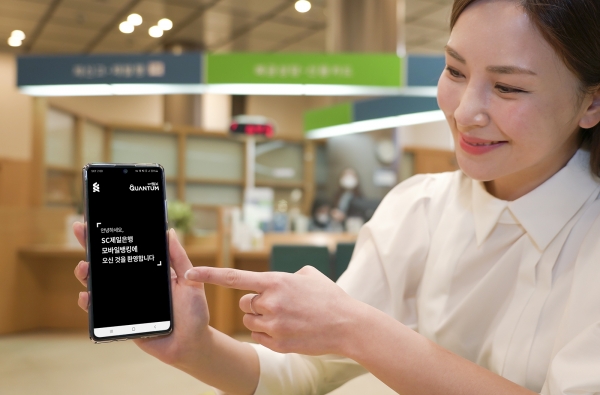 SK텔레콤 홍보모델이 양자보안 모바일 OTP(6자리 숫자)로 비대면 가입, 계좌 개설, 송금 등 다양한 금융 거래를 안전하게 할 수 있는 SC제일은행 모바일뱅킹 앱을 소개하고 있다. (사진=SK텔레콤)