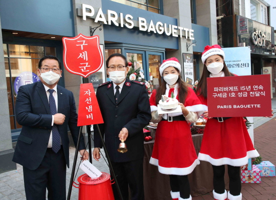 26일 서울 종로구 파리바게뜨 카페대학로점 앞에서 구세군 자선냄비 안에 이명욱 파리바게뜨 부사장(왼쪽)이 성금을 넣고 있다. 오른쪽은 곽창희 구세군자선냄비본부 사무총장 (사진=파리크라상)