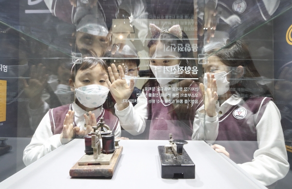 경기도 과천시 국립과천과학관에 마련된 KT 텔레 뮤지엄 특별전시관 방문한 관람객들이 모스부호 음향전신기를 관람 체험하고 있다. (사진=KT)