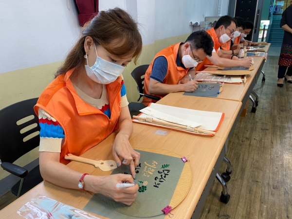 한화디펜스 자원봉사 단체인 '리더스 드림팀'이 지역 내 어르신들에게 전달할 부채에 캘리그라피 작업을 하고 있다. (사진=한화디펜스)