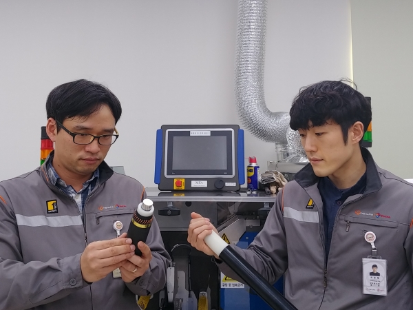 한화토탈 연구원들이 국가기술표준원으로부터 신기술 인증을 받은 ‘재활용이 가능한 전력 케이블용 폴리프로필렌’(전력 케이블 흰 색 중간층)을 살펴보고 있다. (사진=한화토탈)