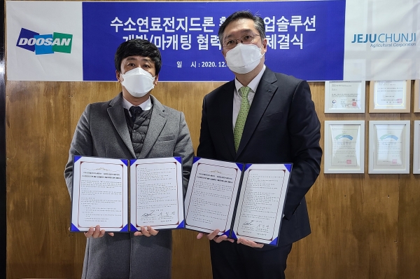 이두순 두산모빌리티이노베이션 대표(오른쪽)와 송진영 제주천지 대표가 '수소연료전지드론을 활용한 농업 솔루션 개발' 업무협약식을 마치고 기념사진을 촬영하고 있다. (사진=두산모빌리티이노베이션)