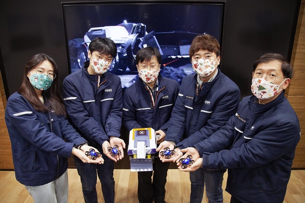 두산인프라코어 임직원들이 온라인 주니어공학교실 진행에 앞서 ‘콘셉트-엑스’ 교보재를 가지고 기념사진을 촬영하고 있다. (사진=두산인프라코어)