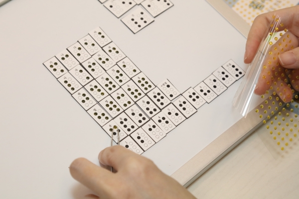 GS칼텍스 임직원 자원봉사자가 점자일람표를 자석형태로 제작하고 있다. (사진=GS칼텍스)