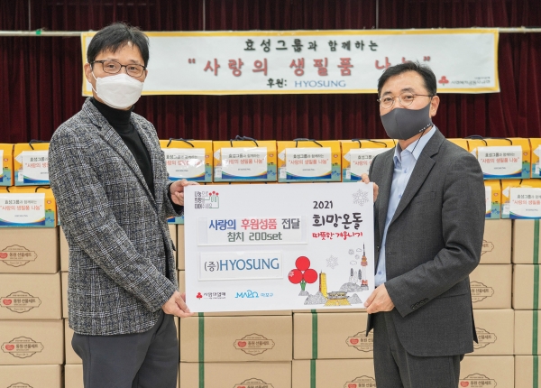 최형식 효성 커뮤니케이션실 상무(오른쪽)가 김건탁 아현동장에게 취약계층을 위한 생필품을 전달한 뒤 기념 사진을 찍고 있다. (사진=효성)