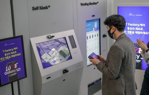 SKT 갤럭시S21 개통 행사에서 1호 개통 고객 배인우씨(서울)가 무인 매장을 통해 폰을 수령하고 있다. (사진=SK텔레콤)