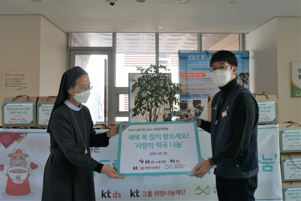 성남시독거노인종합지원센터 파스칼 수녀(왼쪽)와 김명식 KT DS 노조위원장이 떡국 패키지 포장을 완료하고 기념 촬영한 모습. (사진=KT DS)