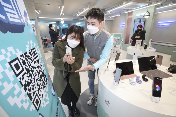 KT매장을 방문한 고객이 '우리매장핫딜' QR 코드를 촬영하고 있다. (사진=KT)