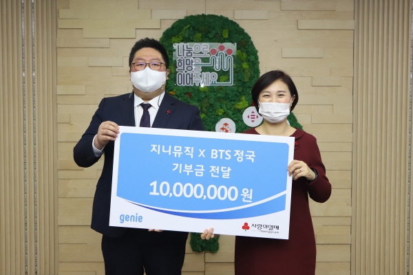 배대선 지니뮤직 전략마케팅실 서비스마케팅팀장(왼쪽)이 신혜영 사랑의열매 자원개발본부장에게 기부금을 전달하는 모습. (사진=지니뮤직)