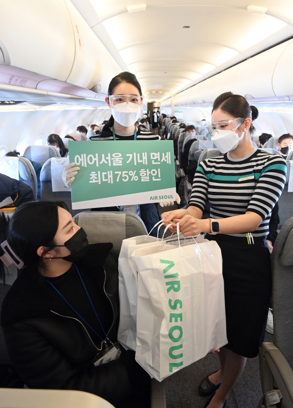 에어서울 승무원이 고객들에게 기내 면세품을 전달하고 있다. (사진=에어서울)
