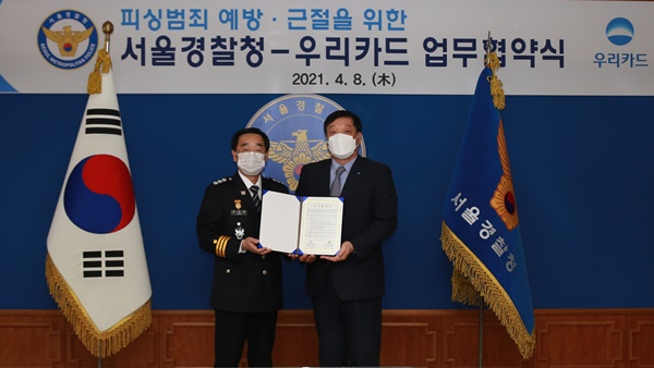 허정진 우리카드 부사장(오른쪽)과 장하연 서울경찰청장이 이달 8일 종로구 서울경찰청에서 피싱범죄 예방을 위한 업무협약을 맺고 기념사진을 촬영하고 있다. (사진=우리카드)