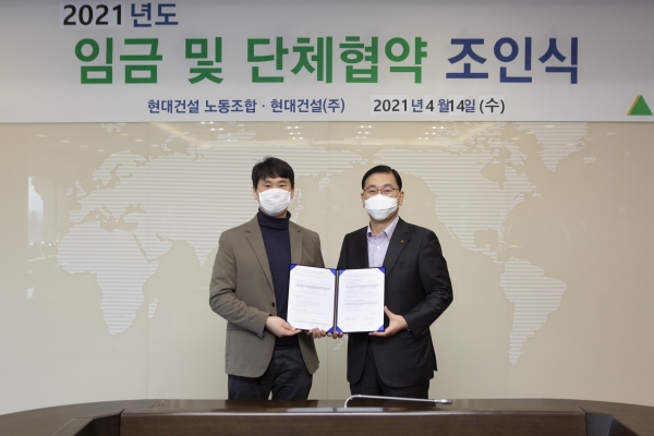 14일 서울 종로구 현대건설 계동사옥에서 열린 '2021년도 임금 및 단체협약 체결식'에서 윤영준 현대건설 대표이사(오른쪽)와 김준호 노조위원장이 협약서에 서명한 뒤 기념사진을 찍고 있다.(사진=현대건설)