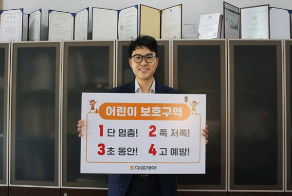 어린이 교통안전 릴레이 챌린지에 동참한 전승호 대웅제약 대표이사 사장이 '1단 멈춤! 2쪽 저쪽! 3초 동안! 4고 예방!'이 적힌 팻말을 들어 보이고 있다. (사진=대웅제약) 