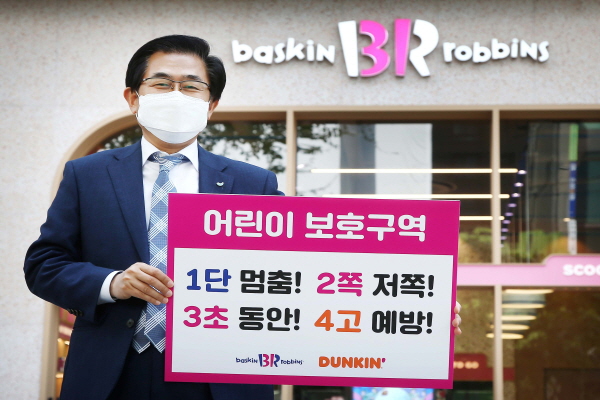 어린이 교통안전 릴레이 챌린지에 참여한 도세호 비알코리아 대표가 서울 서초구 배스킨라빈스 서초우성점 앞에서 어린이 교통안전 표어가 적힌 팻말을 들어 보이고 있다. (사진=비알코리아)