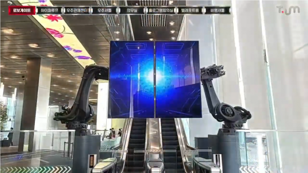 SK텔레콤 서울 을지로 본사 1층에 위치한 티움 입구. 지하철 게이트처럼 생긴 입구 위에서 거대한 로봇팔 2개가 자유자재로 움직인다. (사진=티움 온택트 영상 갈무리)