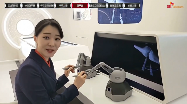 안내원은 감각통신을 이용한 감각전달장치로 인공 뼈 이식 수술을 직접 집도한다. 손으로 감각전달장치를 잡고 화면 속 수술 도구를 조작한다. (사진=티움 온택트 영상 갈무리)