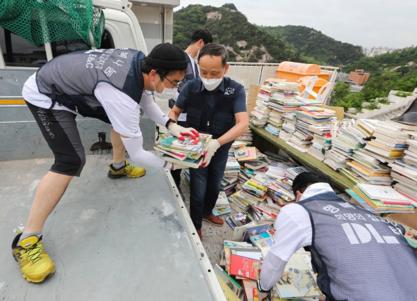 이규성 주택사업본부장(가운데)과 직원들이 서울시 종로구에 위치한 선덕원에서 폐기물을 나르고 있다. (사진=DL이앤씨)
