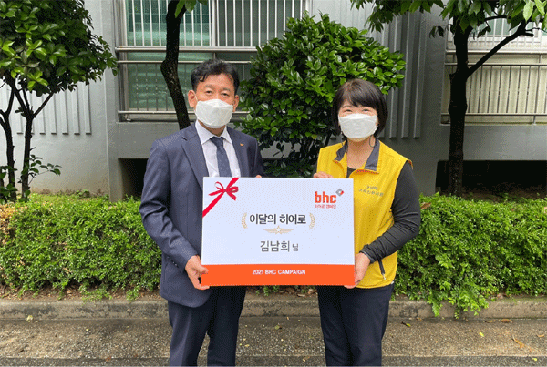 김용희 bhc 가맹운영사업부 이사(왼쪽)가 지난 17일 경남 김해시에서 김남희씨한테 '이달의 히어로' 상장과 치킨 상품권을 건네고 있다. (사진=bhc) 