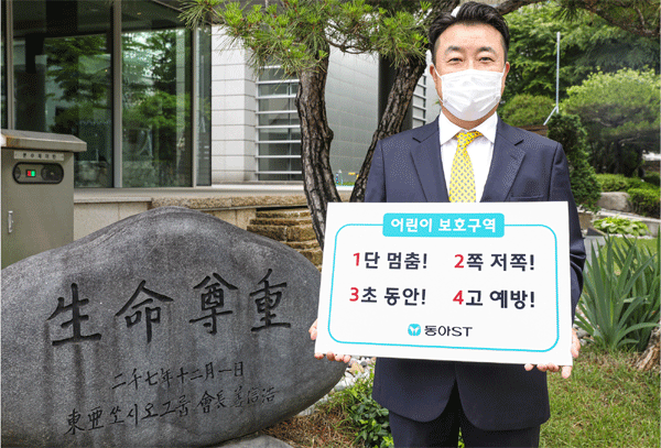 어린이 교통안전 릴레이 챌린지에 동참한 한종현 동아에스티(ST) 대표이사 사장이 서울 동대문구 동아쏘시오그룹 본사에서 '어린이 보호구역 1단 멈춤! 2쪽 저쪽! 3초 동안! 4고 예방!'이 적힌 팻말을 들어 보이고 있다. (사진=동아쏘시오홀딩스) 