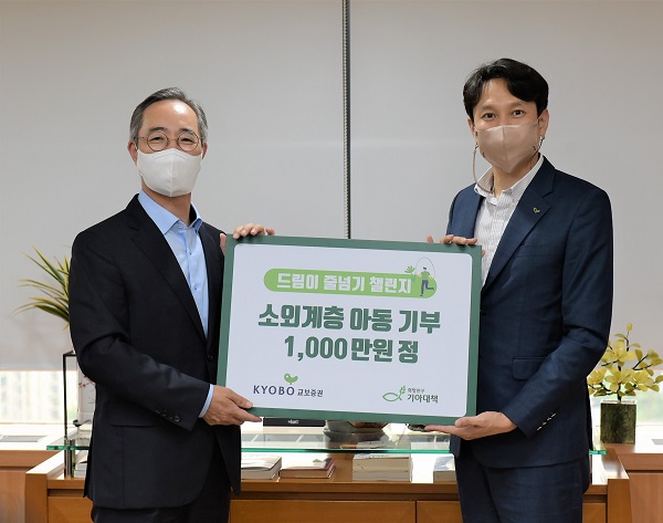 이석기 교보증권 대표이사(왼쪽)이 기부금을 전달하고 정규상 기아대책 본부장과 기념사진을 촬영하고 있다.(사진=교보증권)