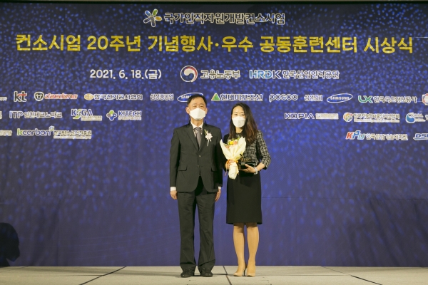 18일 서울 가든호텔에서 열린 '컨소시엄 20주년 기념행사·우수 공동훈련센터 시상식'에서 진영심 KT 그룹인재개발실장 상무(오른쪽)가 박화진 고용노동부 차관에게 최우수 기관상을 수상하는 모습. (사진=KT)