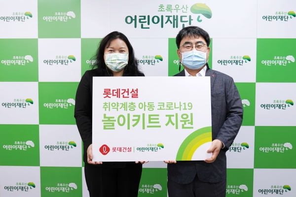 최운정 초록우산어린이재단 본부장과 한정호 롯데건설 상무(오른쪽)가 서울지역 아동을 위한 '놀이 키트' 전달식을 진행했다. (사진=롯데건설)