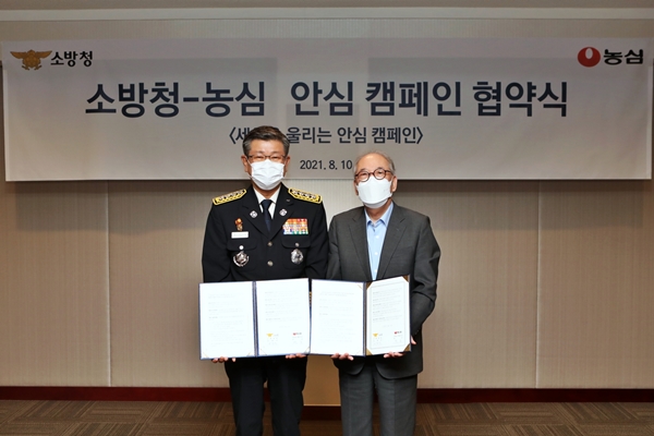 10일 서울 동작구 농심 본사에서 박준 농심 대표이사(오른쪽)와 신열우 소방청장이 세상을 울리는 안심 캠페인 업무협약서를 들어 보이고 있다. (사진=농심)