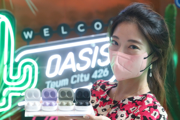 LG유플러스 모델이 강남역에 위치한 복합문화공간 '일상비일상의틈'에서 갤럭시 버즈2를 소개하고 있는 모습. (사진=LG유플러스)