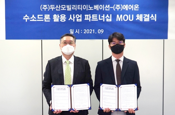 이두순 두산모빌리티이노베이션 대표(왼쪽)와 구자균 ㈜에어온 대표가 업무협약(MOU)을 마치고 기념사진 촬영을 하고 있다. (사진=㈜두산)