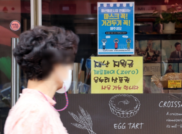 코로나 상생 국민지원금(재난지원금) 지급 절차가 시작된 지난 6일 서울 용산구 전통시장의 한 가게에 코로나 상생 국민지원금 사용 가능 안내 문구가 붙어있다. (사진=연합뉴스)