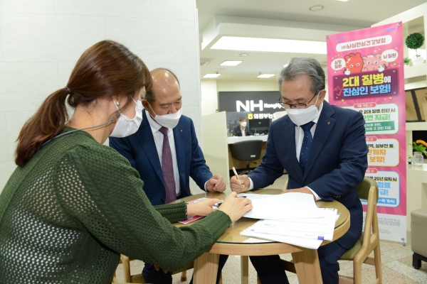 김명수 경기 의정부농협 조합장(오른쪽)이 최창수 NH농협손해보험 대표로부터 상품 설명을 듣고 '뇌심전심건강보험' 1호로 가입하고 있다. (사진=NH농협손해보험)