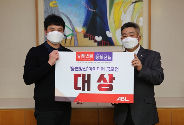 시예저치앙 ABL생명 사장(오른쪽)이 '응변창신(應變創新) 아이디어 공모전'에서 대상을 차지한 하철웅 커뮤니케이션부 차장을 축하하며 기념촬영을 하고 있다. (사진=ABL생명)