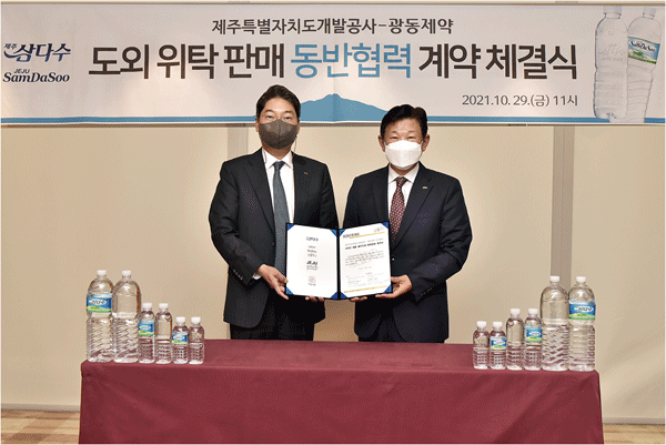 최성원 광동제약 대표이사 부회장(왼쪽)과 김정학 제주특별자치도개발공사 사장이 제주삼다수 위탁 판매 계약서를 들어 보이고 있다. (사진=광동제약) 