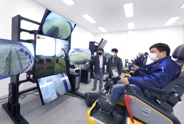 볼보건설기계 엔지니어들이 원격관제센터에서 5G 원격제어 솔루션의 실시간 영상을 보며 흙을 쌓고 땅을 파는 트렌치 작업을 하는 모습. (사진=LG유플러스)