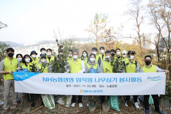 전용범 NH농협생명 경영기획부문 부사장(앞줄 오른쪽 다섯째)과 임직원 일동이 노을공원 나무심기 봉사활동을 기념해 사진을 촬영하고 있다. (사진=NH농협생명)